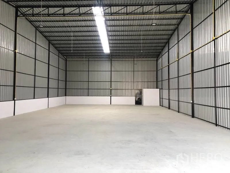 Warehouse for rent in Pathum Thani - Spacious warehouse interior with high steel truss roof, skylight strip and polished concrete floor.