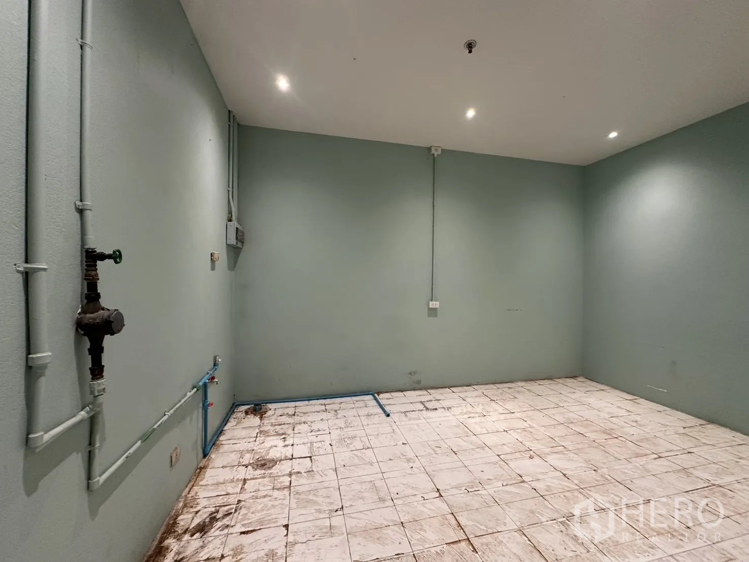 零售空间 for rent in Watthana, Bangkok - 后区房间，浅绿墙面、瓷砖地面，管线与给排水预留点清晰可见。