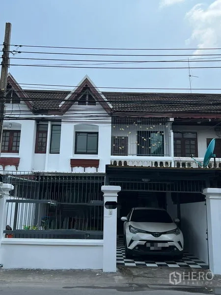 联排别墅 出租在Din Daeng, Bangkok - 联排外立面，山墙屋顶与带门的有顶车库。