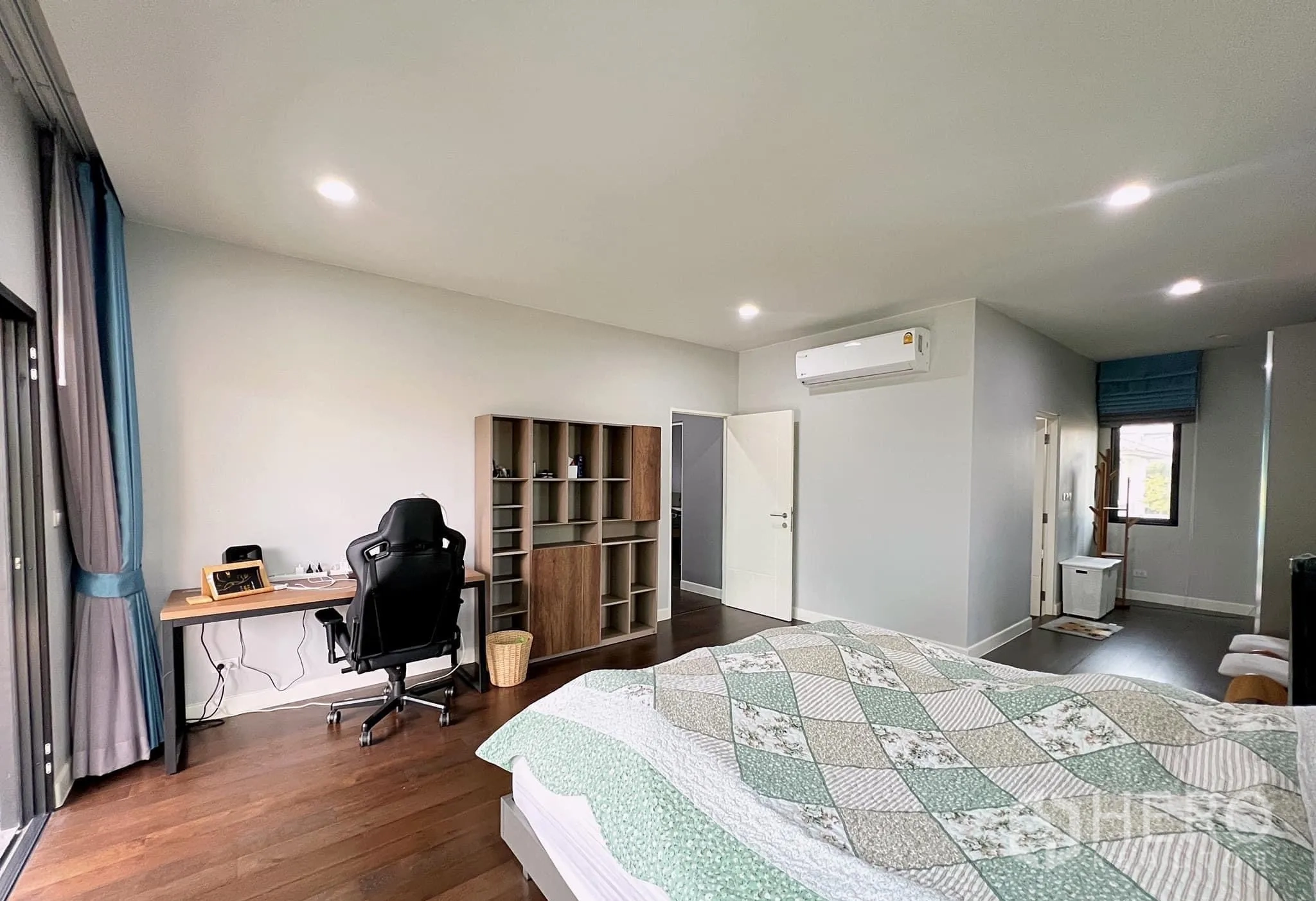 Detached House for rent or sale in Lam Luk Ka, Pathum Thani - Master suite view showing work desk, shelving and corridor to closet.