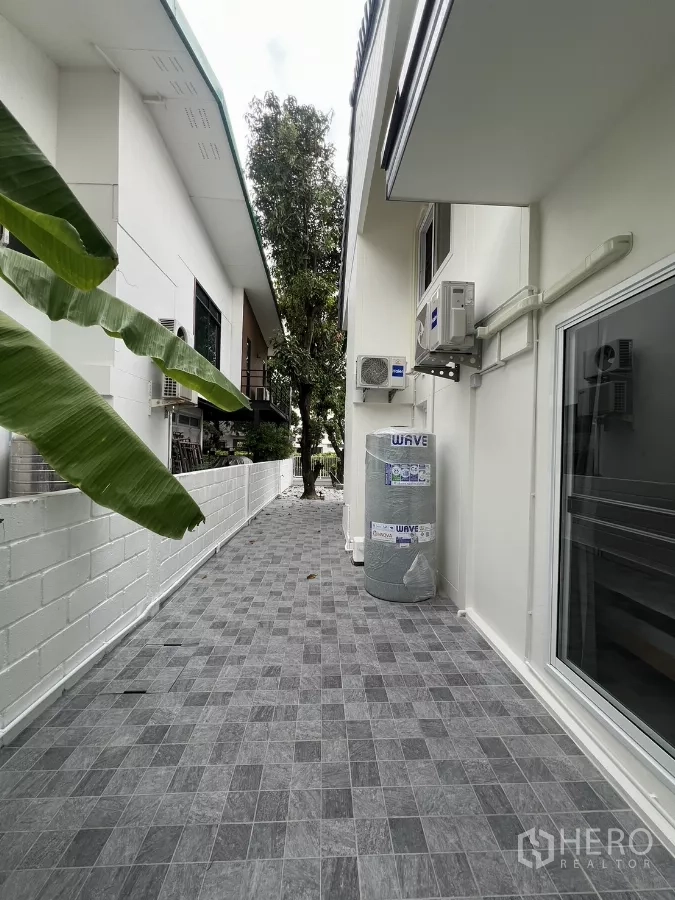Detached House for rent in Saphan Sung, Bangkok - Long service walkway with water tank and air conditioners along the house side.