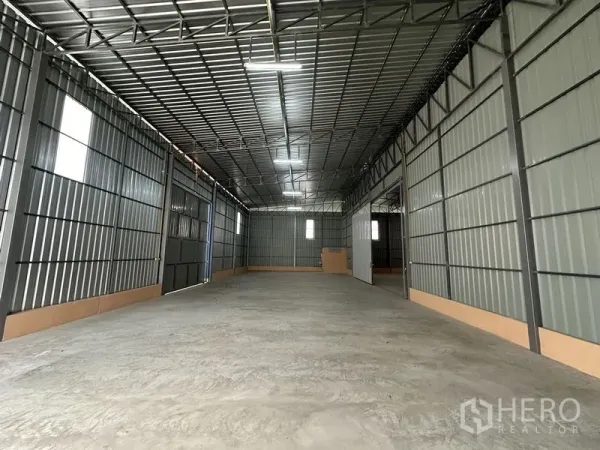 Warehouse for rent in Bueng Kum, Bangkok - Spacious warehouse interior with high steel truss roof, concrete floor and windows for natural light.