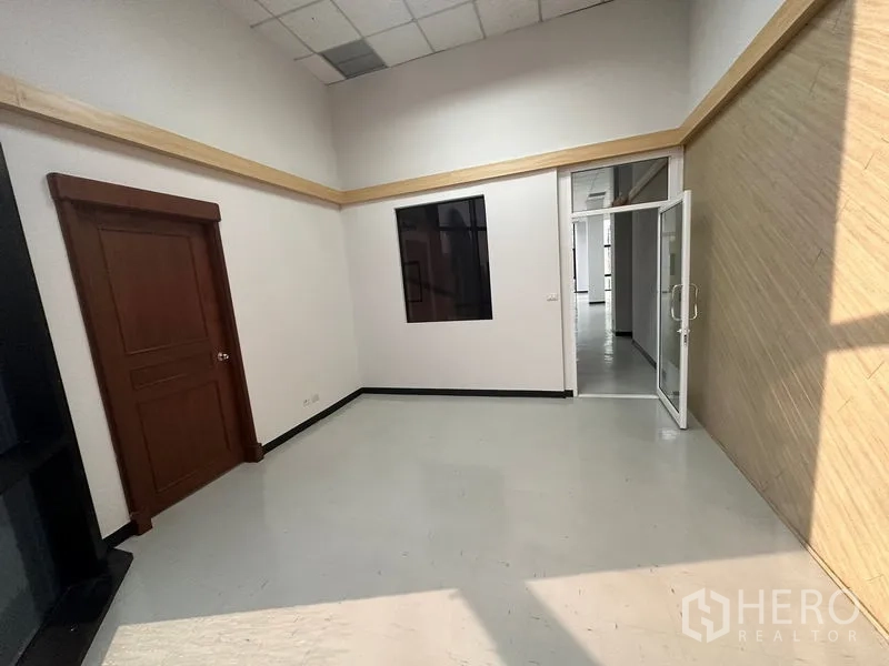 办公空间 出租 - 接待区或经理室，木门与室内窗，纹理墙面通向主办公区。
