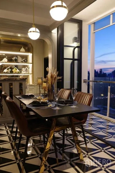 Condominium for sale - Evening dining area with pendant lights and city view balcony.