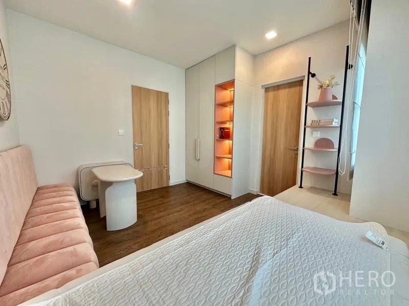 Detached House for rent in Samut Prakan - Kids’ bedroom view with built-in cabinet, illuminated shelves and wooden doors.