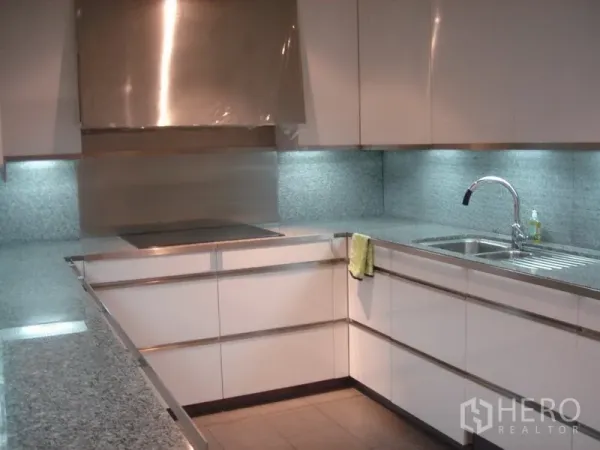 Condominium for rent in Sathon, Bangkok - U-shaped modern kitchen with granite countertops, induction hob and under-cabinet lighting.