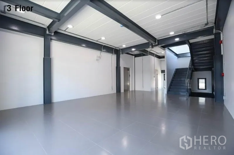 Warehouse for rent in Wang Thonglang, Bangkok - Third-floor open-plan workspace with steel beams, LED lighting and stairs.