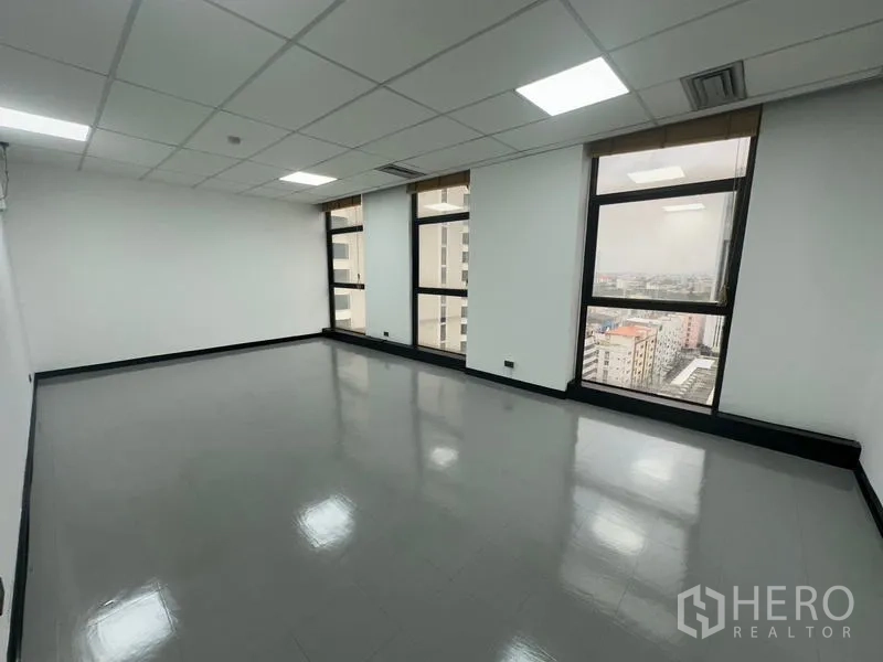 Office Space for rent - Open office with four tall windows providing panoramic city views.