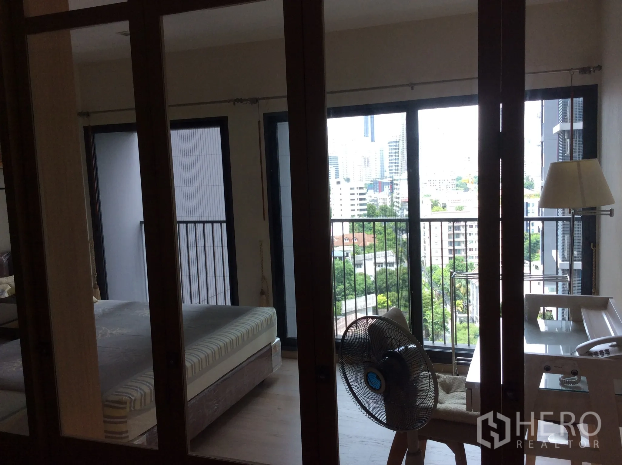 คอนโด ให้เช่าในKhlong Toei, Bangkok - ห้องนอนกั้นกระจก เปิดออกสู่ระเบียงชมวิวเมืองและต้นไม้ พร้อมโต๊ะทำงาน