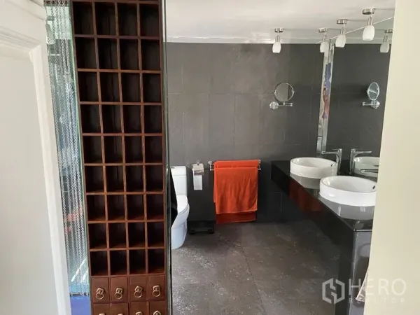 公寓 出售在Khlong San, Bangkok - 现代卫浴，双台盆与大镜面，深色墙砖与毛巾架。