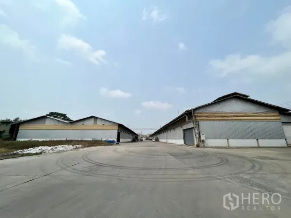 Warehouse for rent in Phra Samut Chedi, Samut Prakan - Central internal road lined with multiple warehouse buildings in a secure estate.