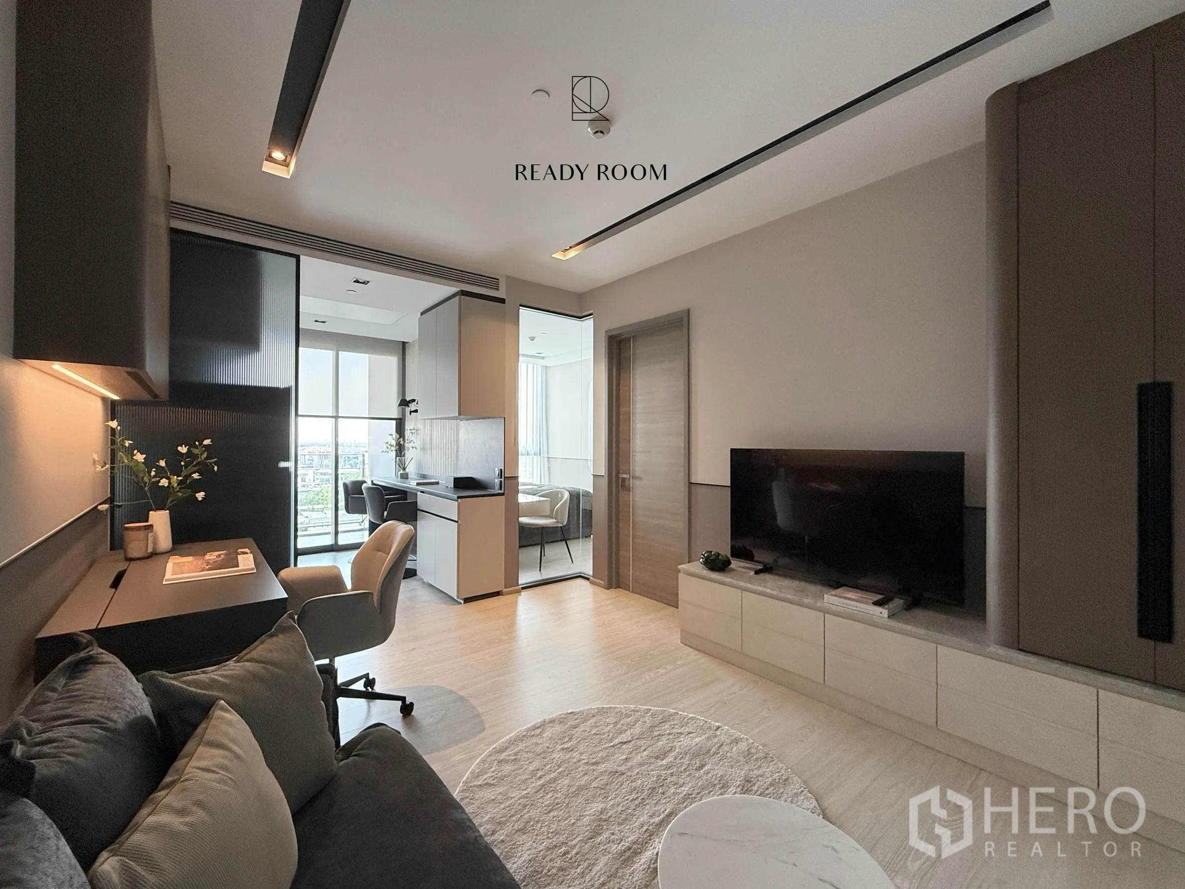 คอนโด for rent in Khlong Toei, Bangkok - ห้องนั่งเล่นพร้อมชั้นวางทีวีและทางเข้าห้องนอนกับระเบียง.