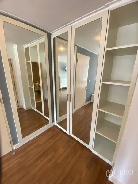 Condominium for rent in Watthana, Bangkok - Corner wardrobe with full-height mirrors and shelving in the dressing area.