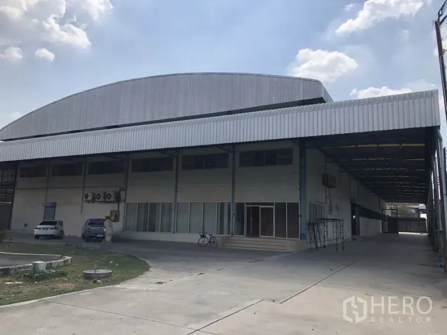 Factory for rent in Sai Noi, Nonthaburi - Front view of a standalone factory with a large covered loading bay and parking area in Sai Noi, Nonthaburi.