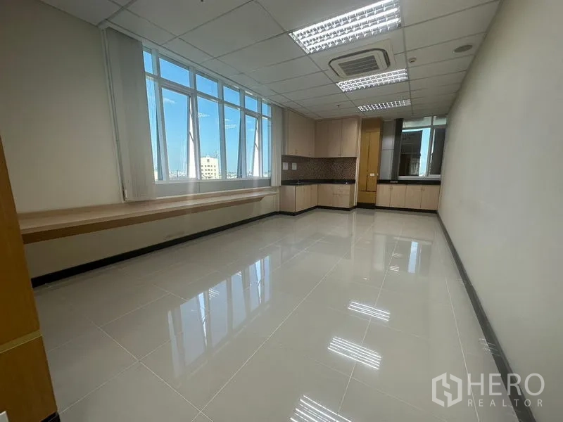 Office Space for rent in Suan Luang, Bangkok - Sunlit coworking area with desks, full-height shelving and glass partitions.