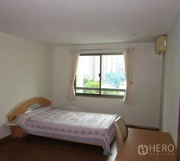 Condominium for rent or sale in Watthana, Bangkok - Secondary bedroom with single bed, desk, and large window facing greenery.