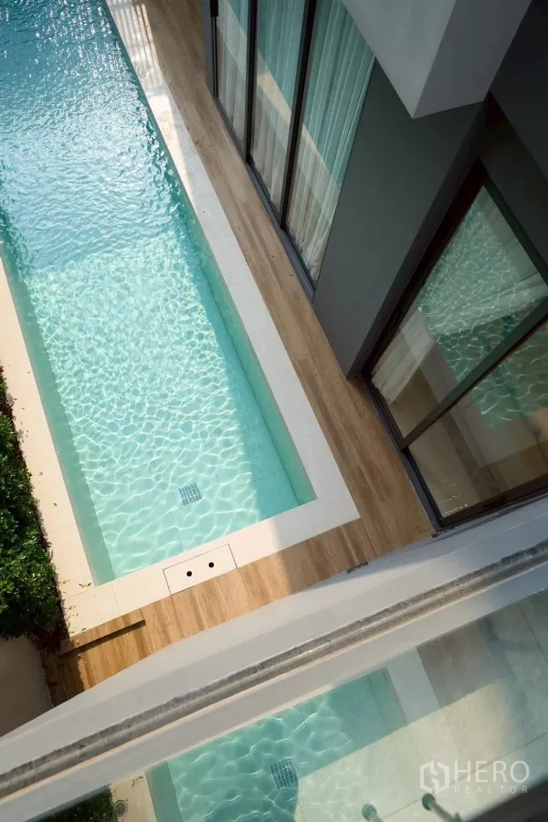 Detached House for sale in Lat Phrao, Bangkok - Narrow private lap pool along the house with wood deck and clear blue water.