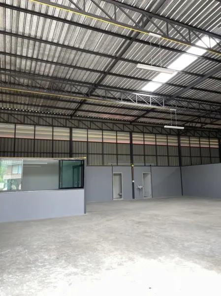 Factory for rent in Khlong Luang, Pathum Thani - Close view of metal truss roof with LED lighting above the office section and restroom doors.