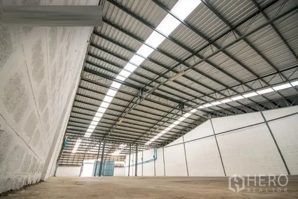 Warehouse for rent - Low-angle view of insulated metal roof and bright ventilation panels along the walls.