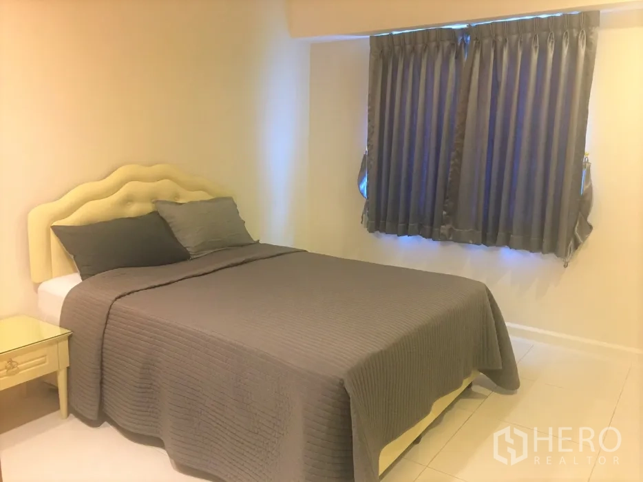 公寓 出租在Watthana, Bangkok - 舒适卧室，软包床头、双人床与灰色窗帘。