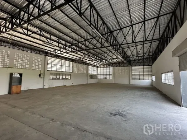 Factory for rent in Lam Luk Ka, Pathum Thani - Spacious factory interior with high steel-truss roof and louvered windows for ventilation.