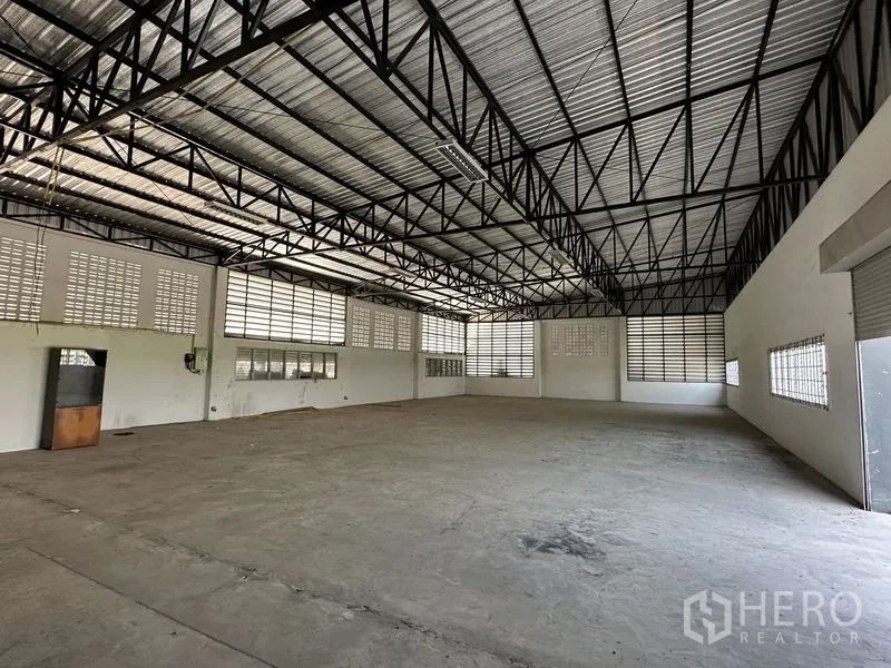 Factory for rent in Lam Luk Ka, Pathum Thani - Spacious factory interior with high steel-truss roof and louvered windows for ventilation.