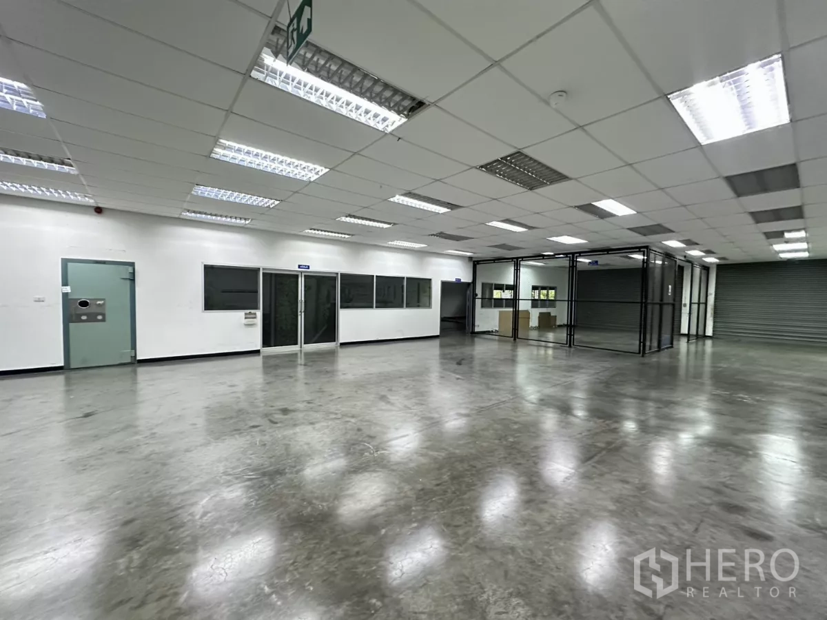 工厂 出售在Lat Krabang, Bangkok - 开放式工作区，玻璃隔间、紧急出口标识与卷闸门。