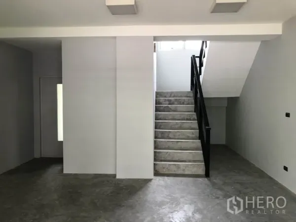 带办公室的家 出租在Wang Thonglang, Bangkok - 一层室内，水泥抛光地面，灰色墙面与黑色扶手楼梯。