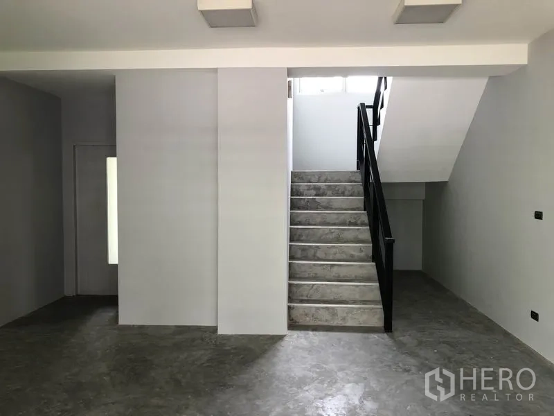 带办公室的家 出租在Wang Thonglang, Bangkok - 一层室内，水泥抛光地面，灰色墙面与黑色扶手楼梯。
