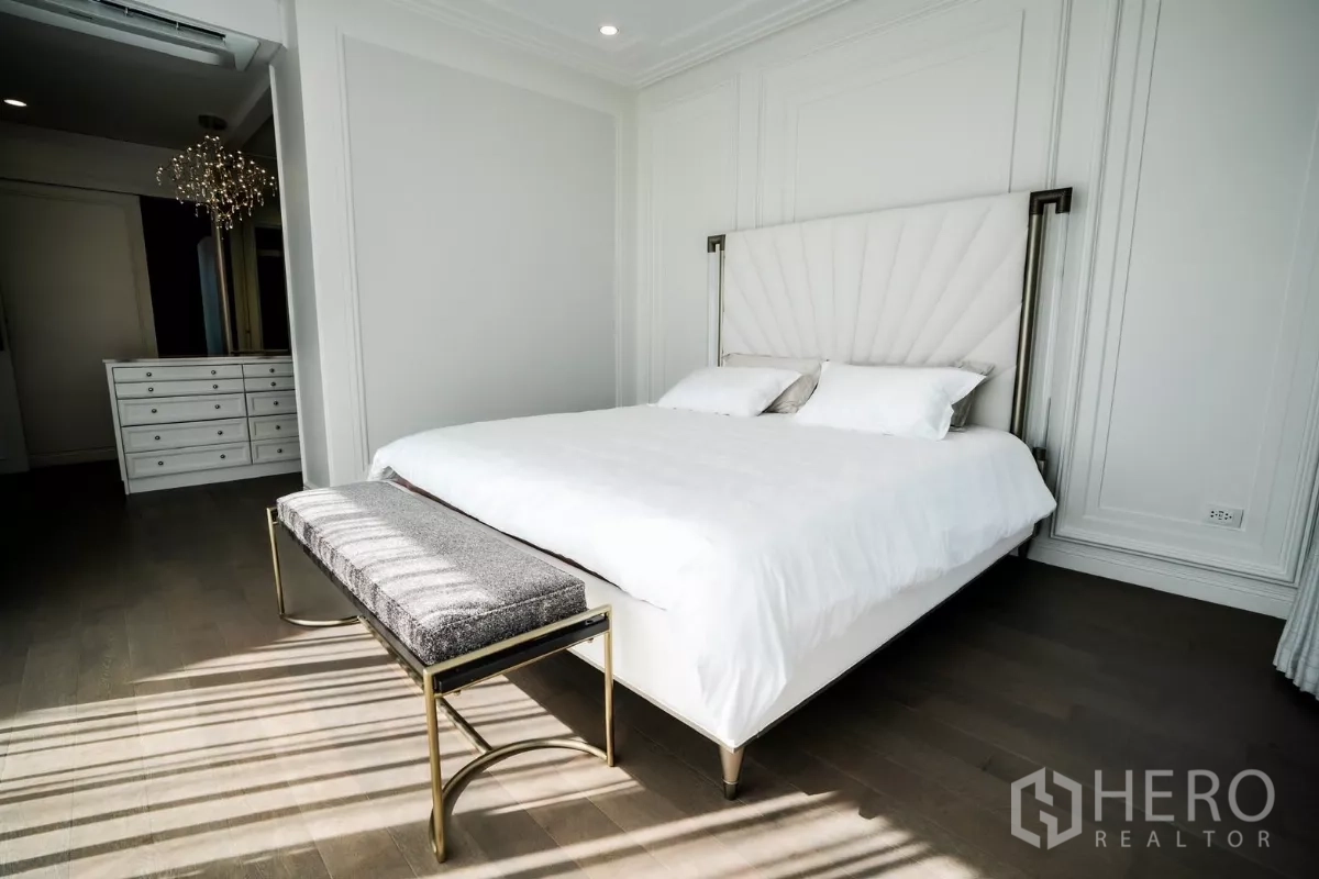 บ้าน ให้เช่าหรือขายในBang Kapi, Bangkok - ห้องนอนใหญ่รับแสงดี หัวเตียงบุนวมและม้านั่งบนพื้นไม้