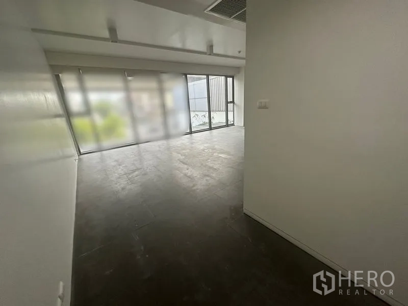 办公空间 出租 - 入口走廊通向明亮的开放式办公区，设大窗与深色地砖。