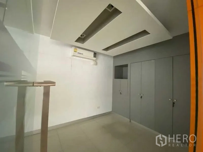 Retail Space for rent - Compact office area with feature ceiling, grey storage lockers and split‑type AC.