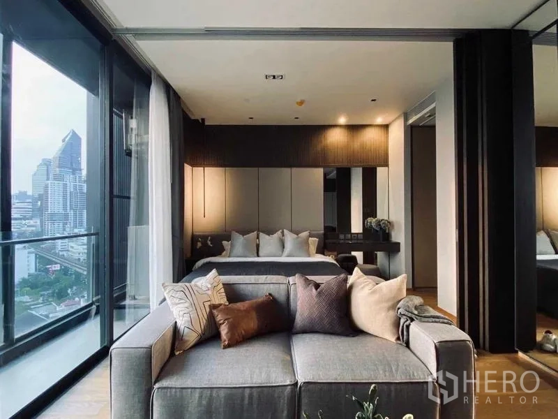 Condominium for rent or sale - Open-plan living and bedroom with floor-to-ceiling windows and city view.