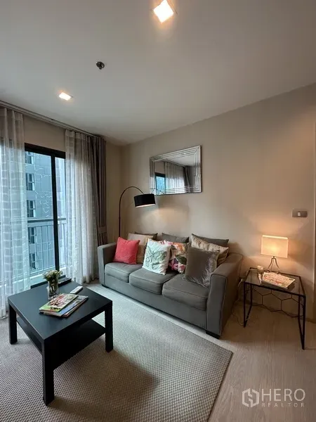 公寓 出租或出售在Khlong Toei, Bangkok - 温馨起居区，沙发、茶几、落地灯与阳台玻璃门。