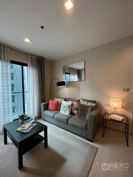 公寓 出租或出售在Khlong Toei, Bangkok - 温馨起居区，沙发、茶几、落地灯与阳台玻璃门。