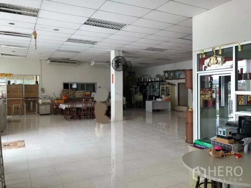 Factory for rent or sale in Lam Luk Ka, Pathum Thani - Spacious tiled lobby and office area with drop ceiling, tables and shelving.