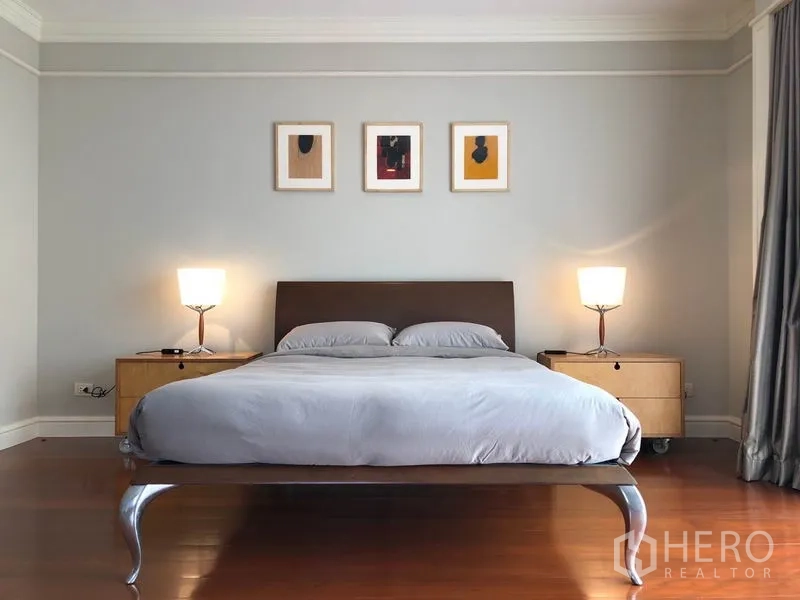 Condominium for rent or sale in Watthana, Bangkok - Minimalist bedroom with double bed, bedside tables, lamps and framed artwork.