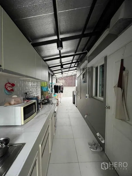 独立式住宅 出租或出售在Lat Krabang, Bangkok - 侧边加建的泰式厨房，带柜体、水槽和洗衣区。