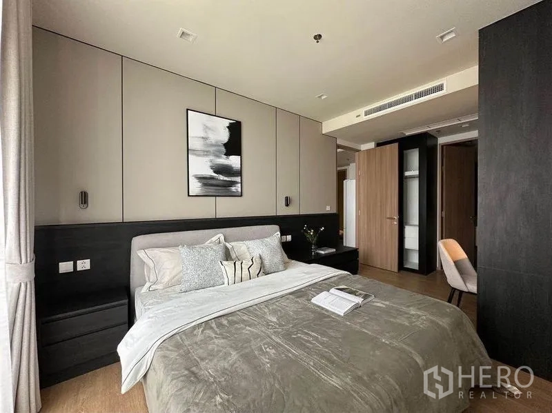 公寓 出租在Watthana, Bangkok - 卧室配灰色床品、护墙板与衣柜储物。