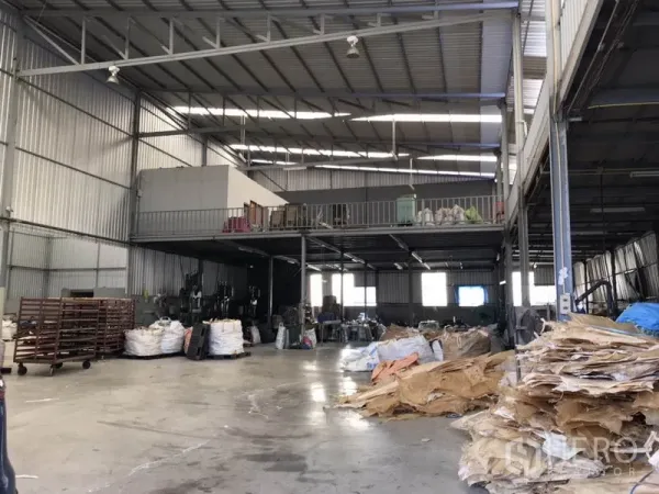 Warehouse for rent in Mueang Samut Prakan, Samut Prakan - Spacious high-clearance warehouse interior with steel frame, mezzanine storage and concrete floor in Mueang Samut Prakan.
