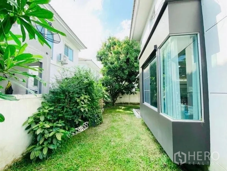 Detached House for rent or sale - Side garden with green lawn, mature tree and hedges beside the home’s bay window.