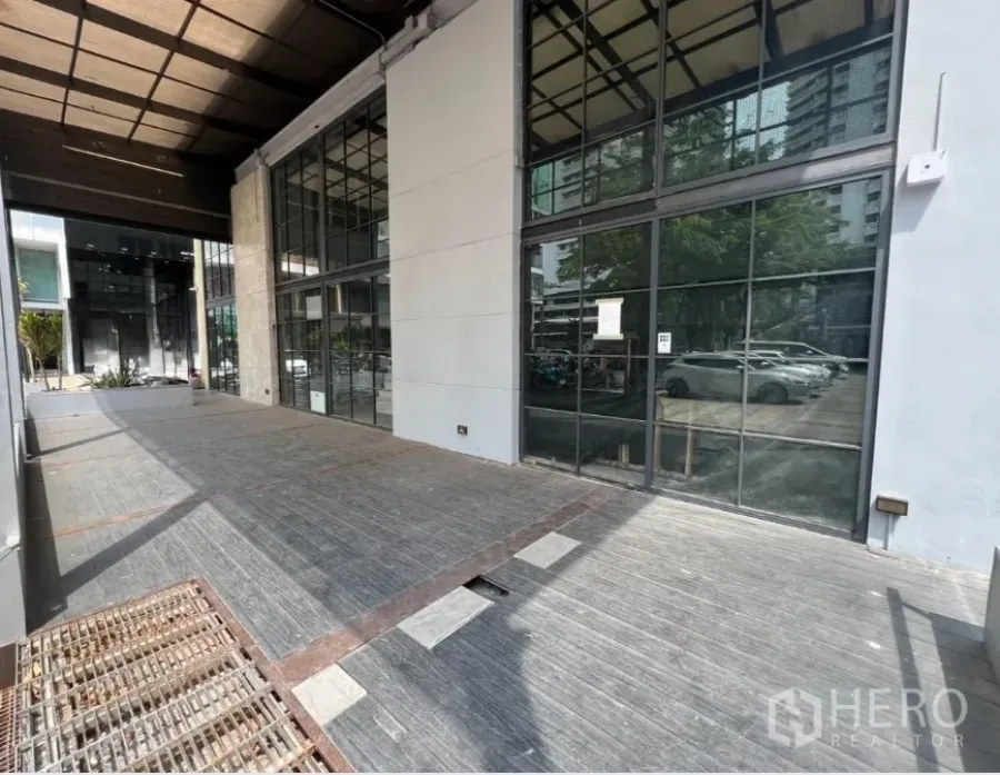 Retail Space for rent in Watthana, Bangkok - Covered terrace with wide floor-to-ceiling glass storefront and parking view.
