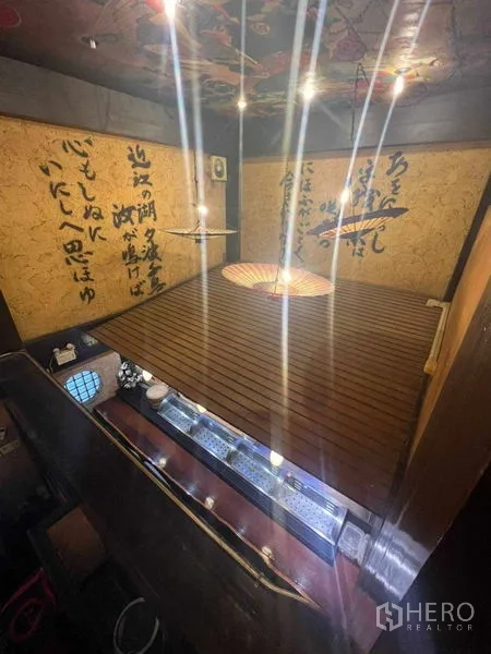 Shophouse for rent in Khlong Toei, Bangkok - Raised tatami platform above the bar area with spotlights and decorative parasols.