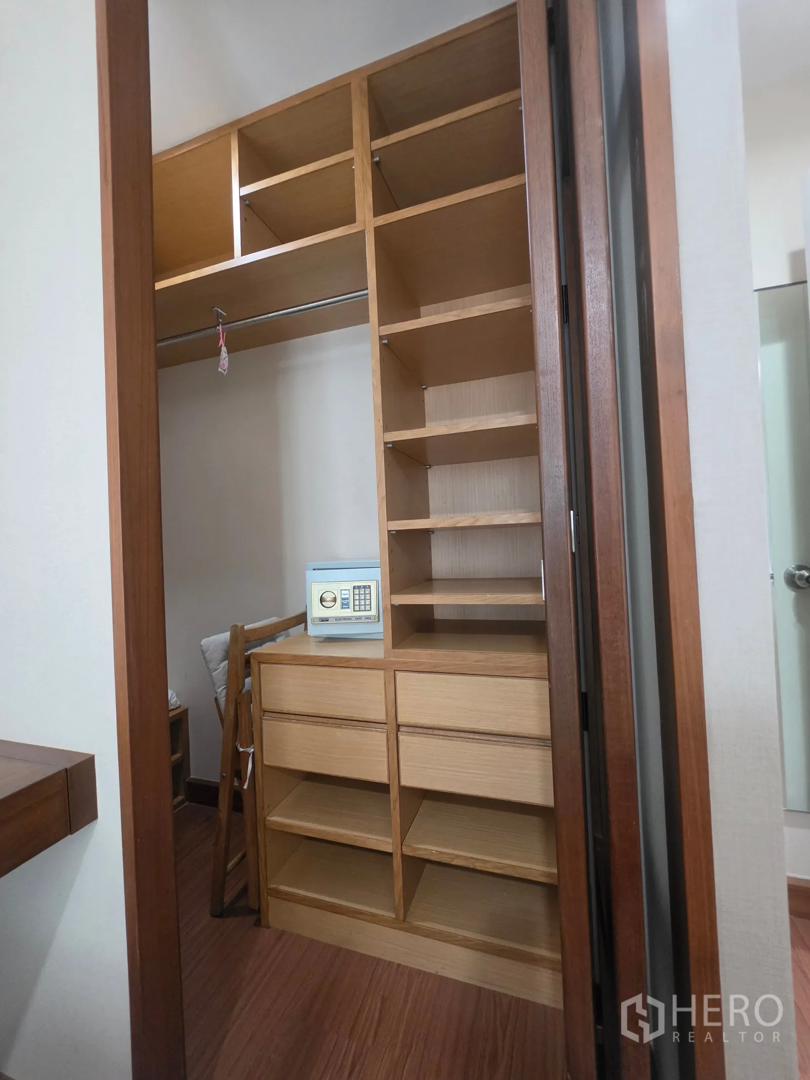 Condominium for rent in Huai Khwang, Bangkok - Walk-in closet with built-in wooden shelves, drawers, and a small safe.