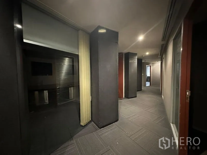 办公空间 出租在Watthana, Bangkok - 昏暗走廊，立柱、玻璃隔断与筒灯