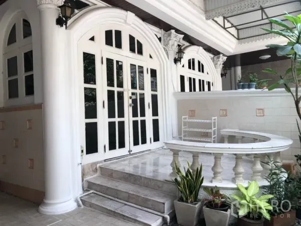 联排别墅 出租在Khlong Toei, Bangkok - 前廊设白色立柱、拱形法式门、台阶与绿植。