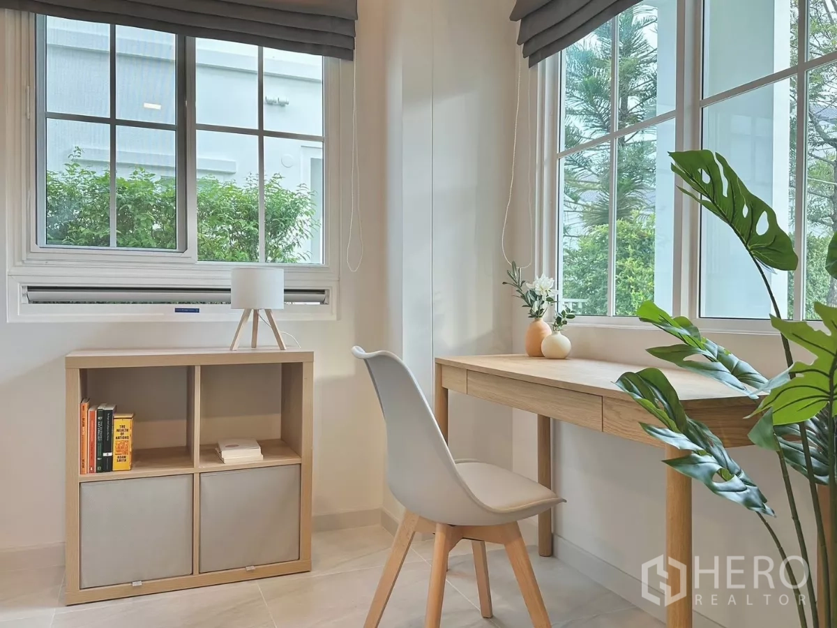 Detached House for rent in Bang Phli, Samut Prakan - Family room centered on a gray sofa, with kitchen beyond and garden on both sides.