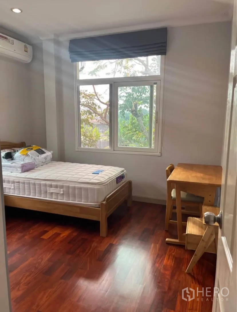 Detached House for rent or sale in Lat Phrao, Bangkok - Additional bedroom with single bed, study table and sunlight from windows.