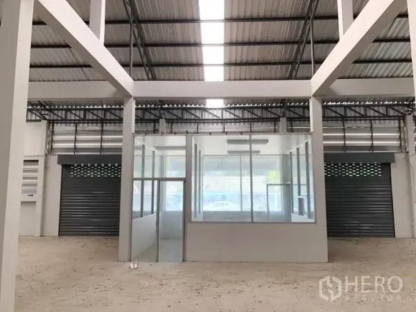 Factory for rent in Bang Bua Thong, Nonthaburi - Central glass-partitioned office inside the factory with roller shutter doors.