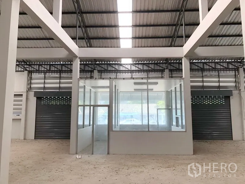 Factory for rent in Bang Bua Thong, Nonthaburi - Central glass-partitioned office inside the factory with roller shutter doors.